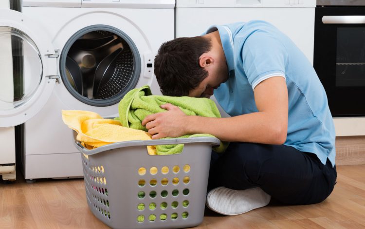exhausted-man-with-laundry-basket-sitting-by-washing-machine-609626966-5abdb1d7ae9ab8003729789d