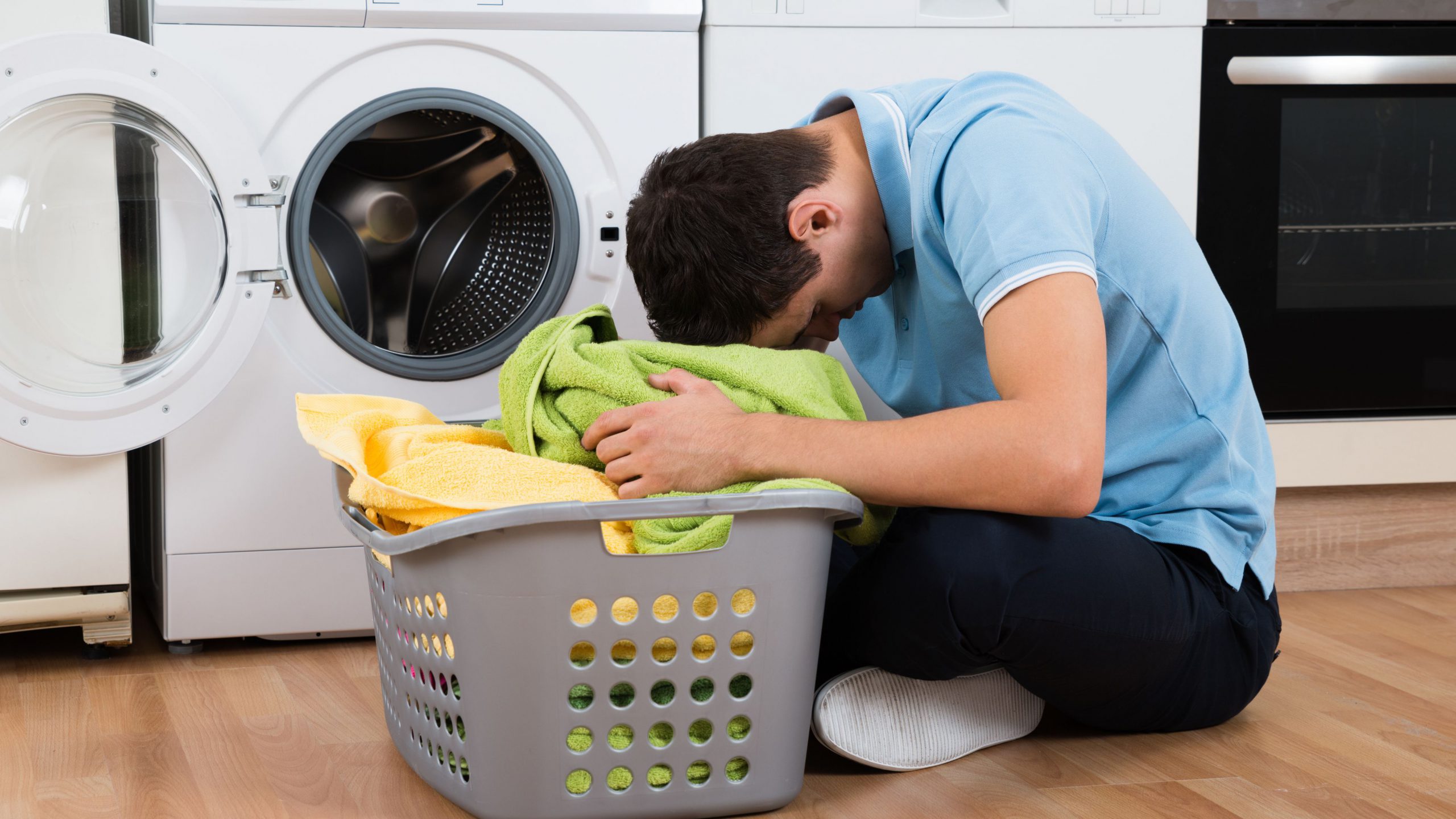 exhausted-man-with-laundry-basket-sitting-by-washing-machine-609626966-5abdb1d7ae9ab8003729789d
